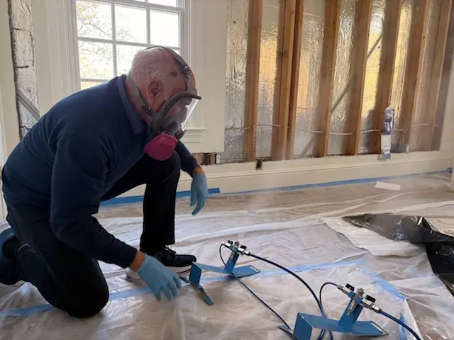 A restoration technician setting drying equipment in a Seattle home stripped to the studs